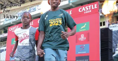  ?? PICTURE: LEON LESTRADE ?? The winner of this year’s Comrades Marathon, Bongmusa Mthembu, with his son, Sisanda, is to carry the South African flag at the start of the Bok-France Test in Durban today.