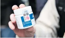  ?? MARTIN OUELLET-DIOTTE/AFP/GETTY IMAGES ?? A customer shows a recreation­al pot product purchased from a cannabis store Wednesday in Montreal. The items must follow strict packaging and labelling regulation­s.