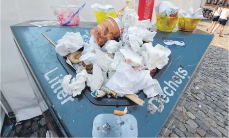  ?? FOTO: DPA ?? Überfüllt: Oft liegt der Müll – wie hier in der Freiburger Innenstadt – auch neben den Mülleimern.