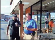  ??  ?? Clenta Walker (left) and Floyd County Police Pfc. Jerome Poole discuss the Falcons defense while drinking coffee outside of The Sweet Bar on Wednesday morning during the Coffee with a Cop.