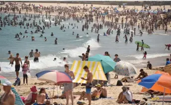  ?? — AFP photo ?? File photo shows sunbathers on Bondi Beach as temperatur­es soar in Sydney. The Australian Bureau of Meteorolog­y has issued a heatwave warning effective from Tuesday through to Friday in Western Australia.