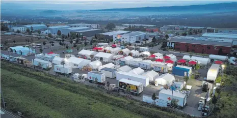  ?? FOTOS: THOMAS FREY/DPA ?? Im Morgengrau­en ist das Verpflegun­gszentrum des Deutschen Roten Kreuzes bereits in Betrieb (Luftaufnah­me mit einer Drohne). Hier werden dreimal täglich mehr als 10 000 Mahlzeiten für die Opfer der Flutkatast­rophe an der Ahr und für die zahlreiche­n Helfer zubereitet.