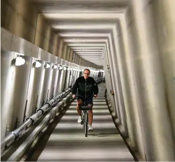  ?? Foto: Daniel Karmann, dpa ?? 30 Meter unter dem See Fahrrad fahren – ein nicht alltäglich­er Berufsallt­ag. Für Alexander Bähr ganz normal. Er radelt durch den Kontrollga­ng im Damm.