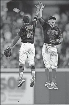 ?? [DAVID DERMER/THE ASSOCIATED PRESS] ?? Indians shortstop Francisco Lindor, left, and right fielder Brandon Guyer go high for a celebrator­y high-five after their victory over the Yankees.