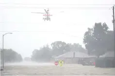  ??  ?? A Coast Guard helicopter flies over a neighbourh­ood after the area was inundated with flooding from Hurricane Harvey in Houston. — AFP photo