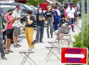  ?? Steve Schaefer/Atlanta Journal-Constituti­on via AP ?? Voters wait in a line stretching around the Metropolit­an Library to vote in Georgia’s primary Tuesday in Atlanta.