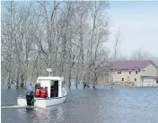  ??  ?? A boat ferries residents to Darlings Island, N.B., cut off by flood waters, on Sunday. Water levels are beginning to stabilize after reaching record levels on the weekend.