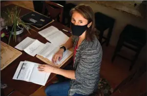  ?? The Associated Press ?? MEDICAL BILLS: Melissa Wilhelm Szymanski sits with some of her medical bills at home on Sept. 19 in Glastonbur­y, Conn. Wilhelm Szymanski got sick earlier this year and wound up with a $3,200 bill because she wasn’t diagnosed initially with COVID-19. Even though dozens of insurers and the federal government are offering to pick up all treatment costs during the pandemic, many holes remain for big bills to surprise patients.