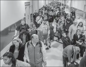  ?? AP/Atlanta Journal-Constituti­on/JOHN SPINK ?? Long lines form Monday in a terminal at Hartsfield-Jackson Atlanta Internatio­nal Airport, a day after an 11-hour blackout brought operations to halt.