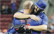  ?? JOHN MINCHILLO/ THE ASSOCIATED PRESS ?? Jake Arrieta hugs catcher David Ross after the final out of his no-hitter against the Reds on Thursday.