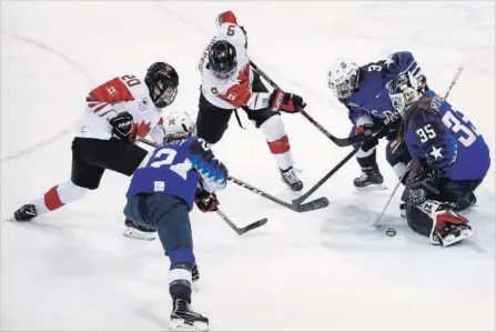  ?? JAE C. HONG THE ASSOCIATED PRESS ?? Goalie Maddie Rooney deflects a shot by Canada’s Sarah Nurse (20) during the second period of Thursday’s gold-medal game, won by the U.S. in a shootout. For more on the game and the Olympics, see pages S4, S5 and S6.