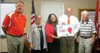  ?? Photo by Susan Holland ?? Kim Johnson, center, community impact manager at United Way of Northwest Arkansas, last week presented Gravette High School principal Jay Chalk with a poster denoting that GHS has been chosen as a recipient of funds under United Way’s First Step...