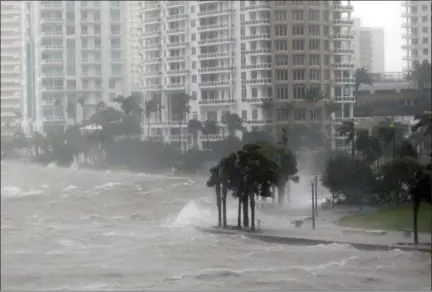  ?? WILFREDO LEE — THE ASSOCIATED PRESS ?? Waves crash over a seawall at the mouth of the Miami River from Biscayne Bay, Fla., as Hurricane Irma passes by in Miami on Sept. 10. Rising sea levels and fierce storms have failed to stop relentless population growth along U.S. coasts in recent...