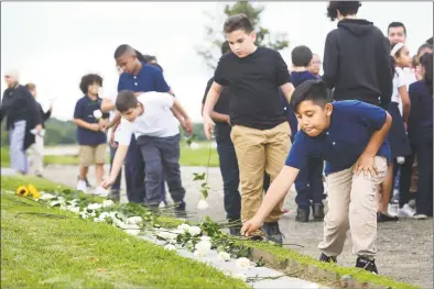  ?? Erik Trautmann / Hearst Connecticu­t Media ?? Andres Lopez , 5th grader at Geraldine W. Johnson School in Bridgeport, lays a rose at the memorial during the State of Connecticu­t’s 18th annual 9/11 Memorial Ceremony honoring and celebratin­g the lives of those killed in the September 11, 2001 terrorist attacks on Thursday at Sherwood Island State Park in Westport. Family members of those who were killed in the attacks participat­ed, and the names of the 161 victims with ties to Connecticu­t were read aloud.