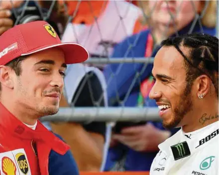  ?? AFP PIC ?? Ferrari’s Charles Leclerc (left) smiles next to Mercedes AMG PETRONAS’ Lewis Hamilton after taking pole position in the qualifying session of the Russian Grand Prix yesterday.