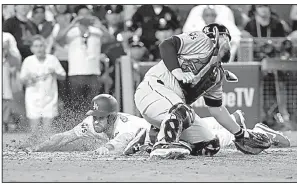  ?? AP/DAVID J. PHILLIP ?? Former Arkansas Razorback Logan Forsythe (left) of the Los Angeles Dodgers slides across home plate in front of a tag by Houston catcher Brian McCann in the 10th inning of Wednesday’s game. Forsythe drew a two-out walk, advanced to second on a wild...