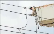  ?? Staci Vandagriff / The Jonesboro Sun via AP ?? Coty Cox, of Craighead Electric, finishes replacing one of the downed power lines Saturday in Jonesboro, Ark.