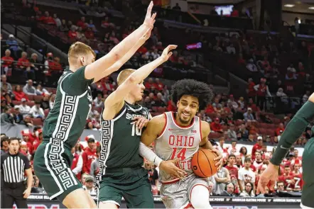  ?? JAY LAPRETE / ASSOCIATED PRESS ?? Ohio State’s Justice Sueing drives the lane against Michigan State’s Carson Cooper (left) and Joey Hauser during the second half Sunday in Columbus. The 14 points scored before intermissi­on were the fewest in a half by a Buckeyes team since 1996.