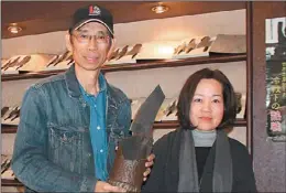  ??  ?? 金門縣「砲彈鋼刀」製造商金合利公司，獲選「台灣精品」。圖為總監吳增棟（左）夫婦展示各式刀具。 （中央社）