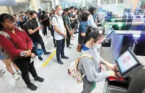  ?? ?? Discipline­d queues: Workers using autogates to clear the Immigratio­n checkpoint in Johor Baru.