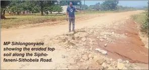  ?? ?? MP Sihlongony­ane showing the eroded top soil along the Siphofanen­i-Sithobela Road.