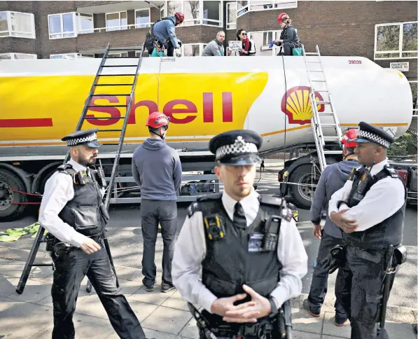  ?? ?? Police officers attend the scene in central London where Etienne Stott, a former Olympian canoeist, and an activist from Extinction Rebellion, climbed on an oil tanker during a protest calling for an end to fossil fuels