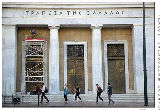  ?? AP file photo ?? Workers repair the facade of the Athens headquarte­rs of the Bank of Greece in June. As Greece’s bailout nears an end, the country now owes $366 billion in debt, or over 180 percent of its annual economic output.