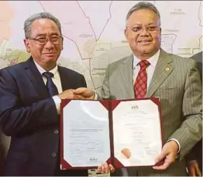  ?? PIC BY MOHD FADLI HAMZAH ?? Election Commission deputy chairman Tan Sri Othman Mahmood (right) handing the returning officer appointmen­t letter to Petaling Jaya Mayor Datuk Mohd Azizi Mohd Zain in Putrajaya yesterday.