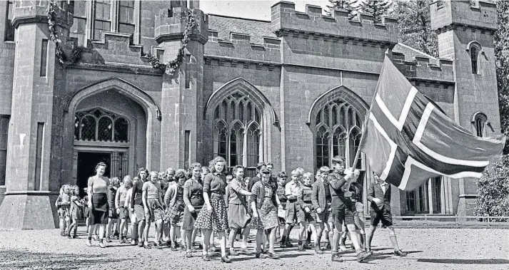  ??  ?? HOME FROM HOME: Schoolchil­dren parade the Norwegian flag after their escape across the North Sea as refugees from the Nazi invasion of their country in April 1940.