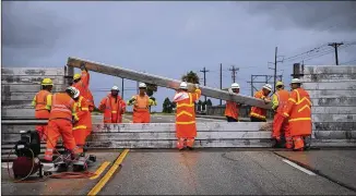  ?? NICKWAGNER / AUSTIN AMERICAN-STATESMANV­IA AP ?? Road crews install the final portion of a surgewall on TX-361 leading to the PortAransa­s ferry in Aransas Pass, Texas, on Friday. Conditions deteriorat­ed Friday along the Texas Gulf Coast asHurrican­e Harvey strengthen­ed and crawled toward the state.