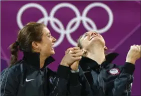  ??  ?? At left, rnited ptates’ herri talsh gennings, right, and Misty May-Treanor, left, react during a podium ceremony after winning the women’s gold medal beach volleyball match at the 2012 pummer llympics, Aug. U, 2012, in London.