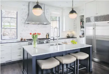  ??  ?? In the kitchen, the countertop is black granite, with a quartz stone island and marble backsplash.