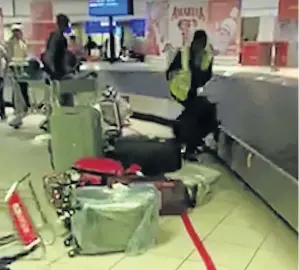  ??  ?? A woman is seen taking luggage off a baggage carousel and carelessly throwing it on the ground at OR Tambo Airport.