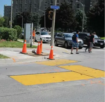  ?? JACK LAKEY/TORONTO STAR ?? Large metal plates covering a utility dig at the southwest corner of Burnhamtho­rpe Rd. and Mill Rd. make a loud ka-thunk when fast-moving vehicles pass over them, which bugs people in nearby apartment buildings.