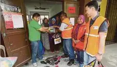  ??  ?? ANGGOTA Briged Sukarelawa­n Media Prima-NSTP mengagihka­n sumbangan kepada mangsa tanah runtuh.