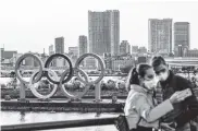  ?? AFP ?? Turistas posando con los símbolos olímpicos en Tokio.