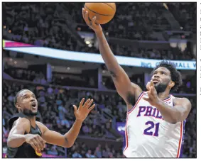  ?? Ron Schwane The Associated Press ?? 76ers center Joel Embiid soars to the basket against Cavaliers forward Evan Mobley during Philadelph­ia’s 118-109 win Wednesday at Rocket Mortgage Fieldhouse.