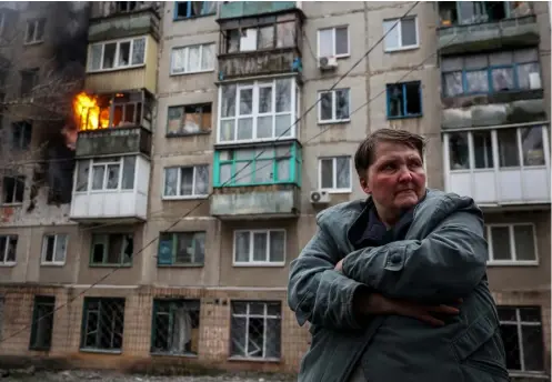  ?? AFP ?? ANOTHER SHELLING. A resident stands in front of a burning building after a shelling in the eastern Ukrainian city of Sloviansk on April 14 amid Russia’s military invasion. It killed at least five people, the local governor said, warning that others could be buried in the rubble.