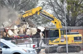  ?? Westside Eagle Observer/MIKE ECKELS ?? A trackhoe takes a bite out of the roof of the old Decatur Elementary building in Decatur Feb. 21. The demolition of the old classroom and office area will make way for the new Decatur Middle School gym.