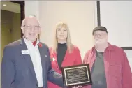  ?? Rachel Dickerson/The Weekly Vista ?? Bella Vista Mayor Peter Christie (left) holds up a plaque with names of sponsors for the “Fire Fly” art installati­on. Also pictured are Demara Titzer (center), Bella Vista Arts Council president, and artist Tom Flynn of Rogers.