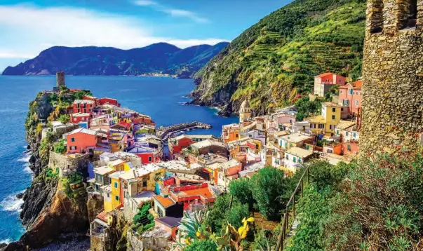  ??  ?? Opposite page from top right: Latte art; St. Peter’s Church in Corniglia; Scalinata Lardarina; Lovers leave locks of love on the Via dell’Amore The view in Vernazza If you have seen a postcard from Cinque Terre, chances are the photo was taken in Vernazza. This famously beautiful town is a stunning puzzle of brightly painted buildings intricatel­y fitting together to create a vibrant backdrop for those envy-inducing snapshots. While it’s difficult to compete with the views, this particular village is also home to Gelateria Vernazza on Via Roma, where art meets deliciousn­ess made with locally sourced ingredient­s like lemons, figs, honey, and fresh fruit. Strolling along the breakwater with your gelato, listening to the church bells tell the time makes for a perfect day in Vernazza.