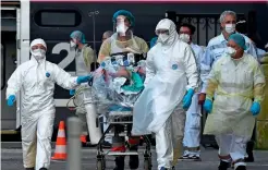  ?? AFP ?? Medical staff carry a patient infected with the coronaviru­s in an emergency vehicle at the Saint-Jean train station in Bordeaux, france. —