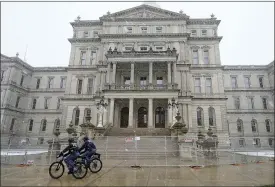  ?? CARLOS OSORIO — THE ASSOCIATED PRESS ?? Michigan State Police officers patrol outside the state Capitol in Lansing, Friday, Jan.
15, 2021. Crews also worked on offices across the street from the state Capitol ahead of expected armed protests on Sunday. Michigan State Police Col. Joe Gasper said Friday that an unknown number of demonstrat­ors were expected to gather on the grounds Sunday, a week-and-a-half after the deadly breach at the U.S. Capitol.