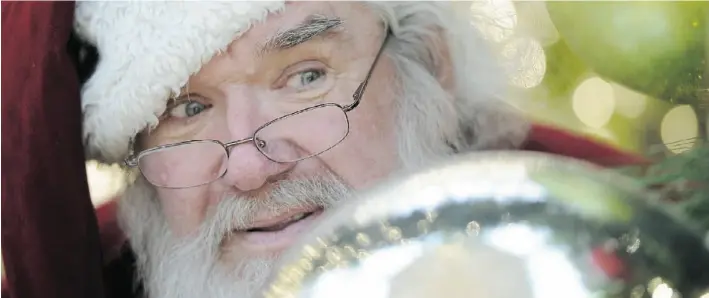  ?? John Lucas/Edmonton Journal ?? Santa plans the logistics of his Christmas Eve run between talking to kids in Bonnie Doon Mall. Nobody really knows how he pulls off this impossible-seeming Christmas thing each year.