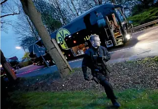  ?? PHOTO: REUTERS ?? Police with the Borussia Dortmund team bus after an explosion near the German team’s hotel. One player was injured.