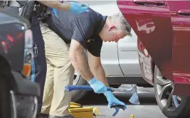  ?? STAFF PHOTO BY NANCY LANE ?? ‘SEVERAL EDGED WEAPONS’: Police probe the scene outside the Kiss 108 studios in Medford after a standoff with a fan who wanted to hear a song collected several weapons, including an ax, above.