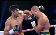  ?? AFP file ?? Vijender Singh (left) throws a punch at WBO Oriental Super Middleweig­ht champion Zulpikar Maimaitial­i. —