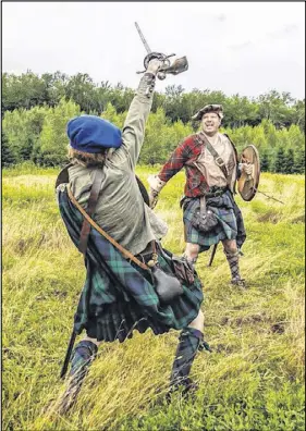  ?? SUBMITTED PHOTO ?? James Finnie, in the background, and his son Argyll take part in a battle reenactmen­t.