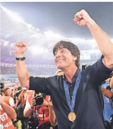 ??  ?? Nach der Siegerehru­ng in Rio: Weltmeiste­r-Trainer Joachim Löw mit Medaille.