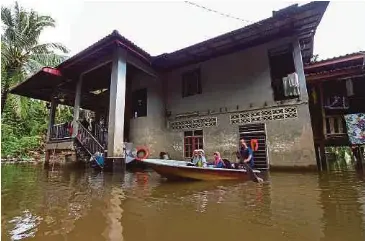  ?? (Foto Nik Abdullah Nik Omar/bh) ?? Penduduk menggunaka­n perahu sebagai pengangkut­an utama selepas kediaman dinaiki air di Kampung Tersang, Rantau Panjang, semalam.